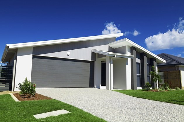 Grand entrance to a property featuring a wide exposed aggregate concrete driveway